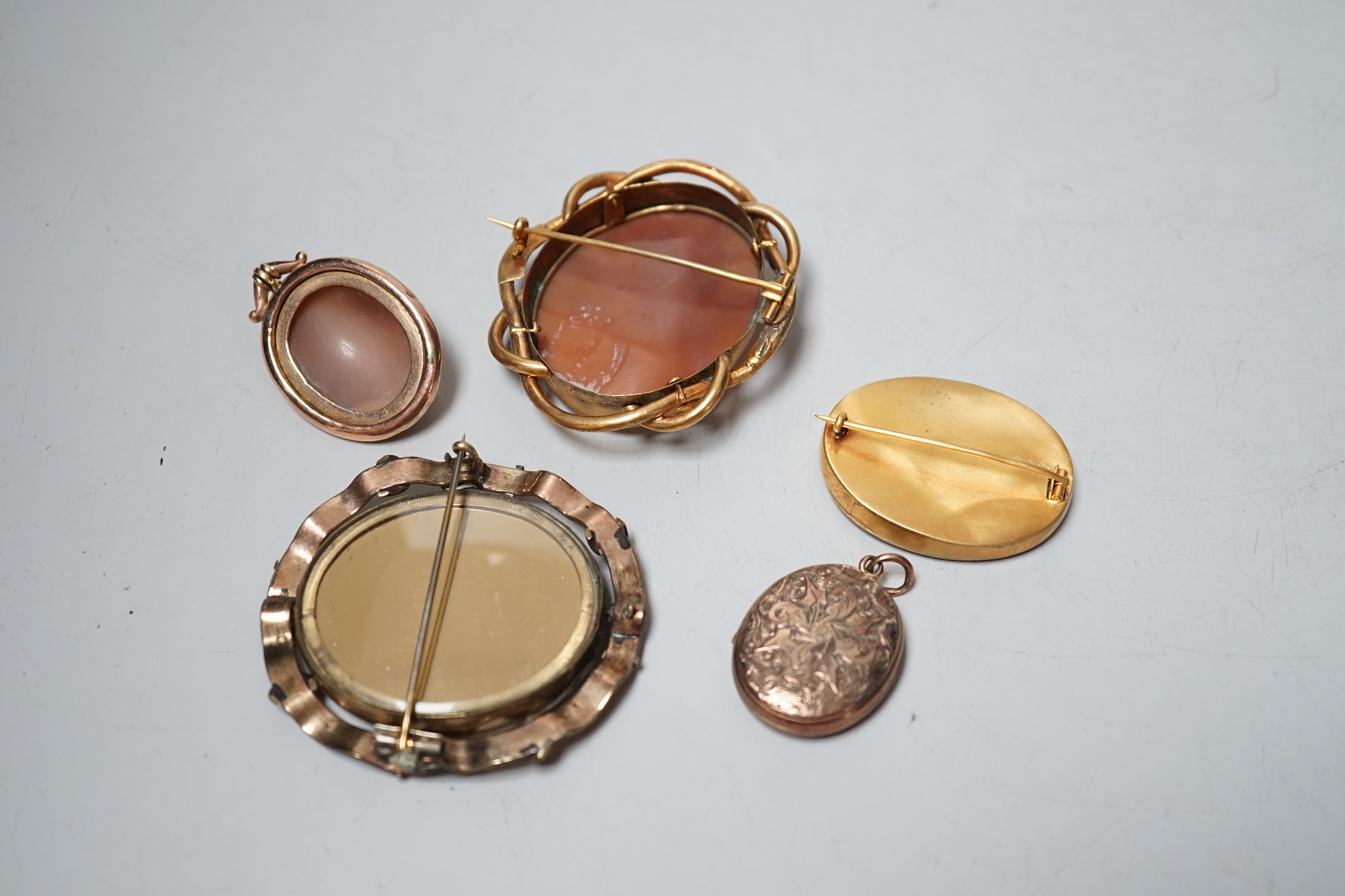 Three assorted gilt metal mounted cameo shell brooches, including bust and The Pliny Doves, largest 60mm, together with a locket and brooch with photograph of a gentleman.